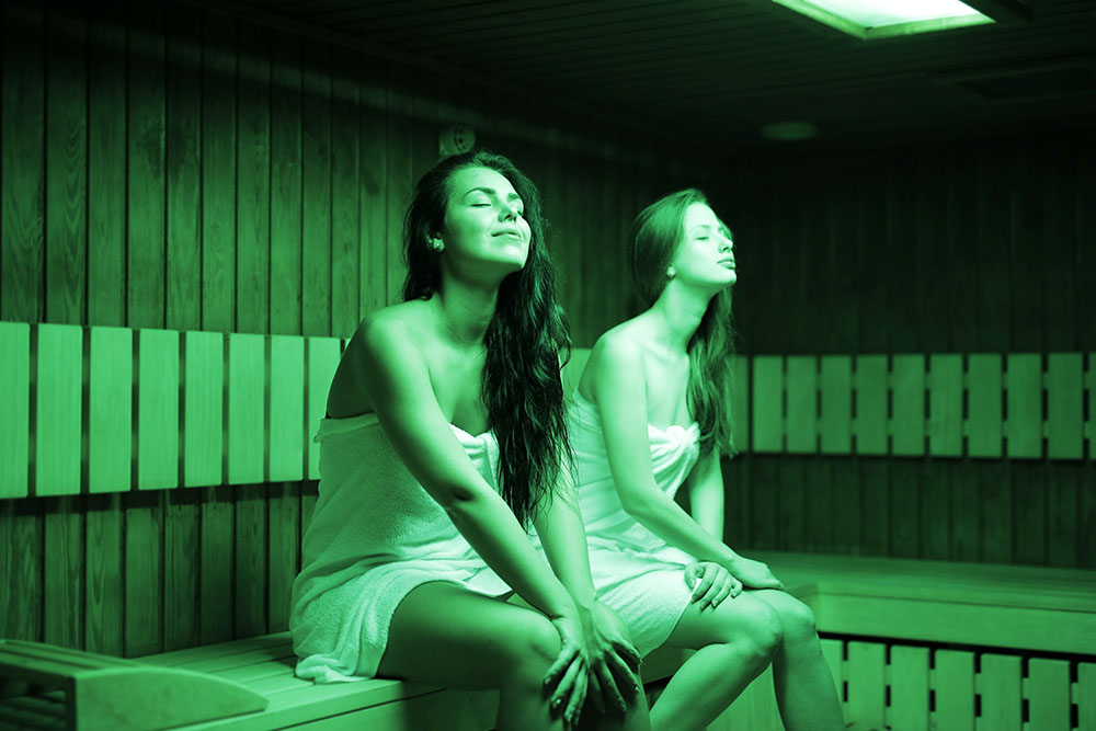 Dos mujeres relajándose dentro de una sauna.