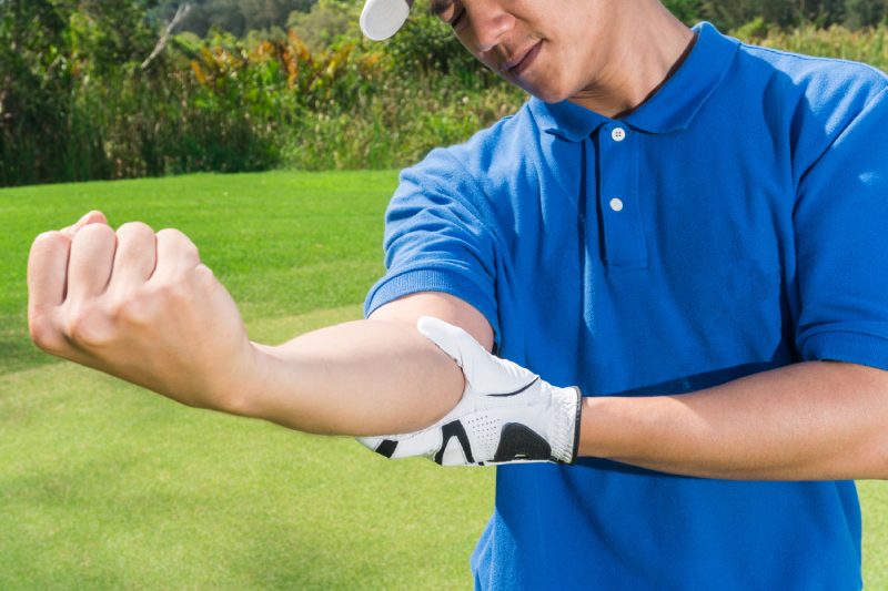 Dolor de codo de golfista durante el juego, concepto de lesión muscular.